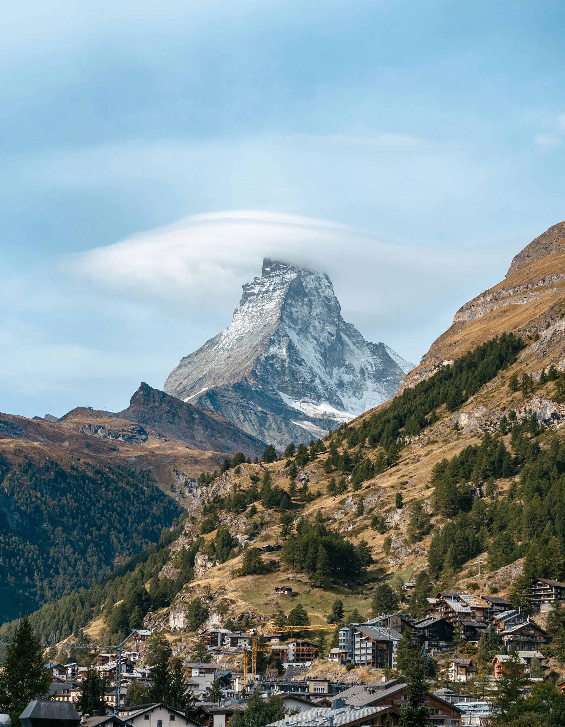 Aktivurlaub in den Bergen - Resort La Ginabelle Zermatt Berg mit Schnee und Wolken über einem Dorf in einem Tal