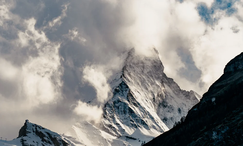 Appartements à Zermatt - Resort La Ginabelle Zermatt Sommet de montagne enneigé partiellement recouvert de nuages sous un ciel bleu