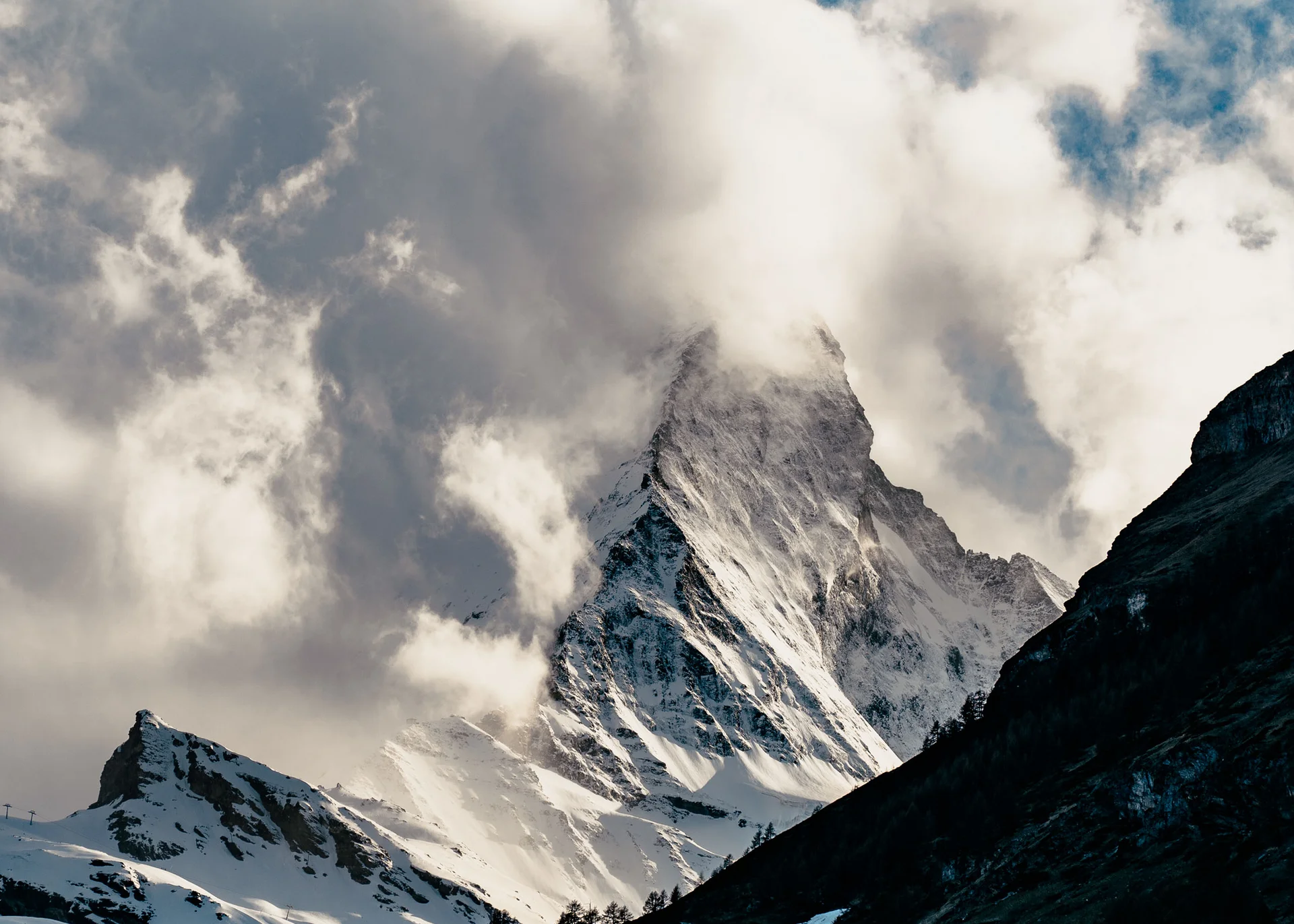 Ausflugsziele in Zermatt - Resort La Ginabelle Zermatt Verschneiter Berggipfel, teilweise von Wolken umgeben vor blauem Himmel