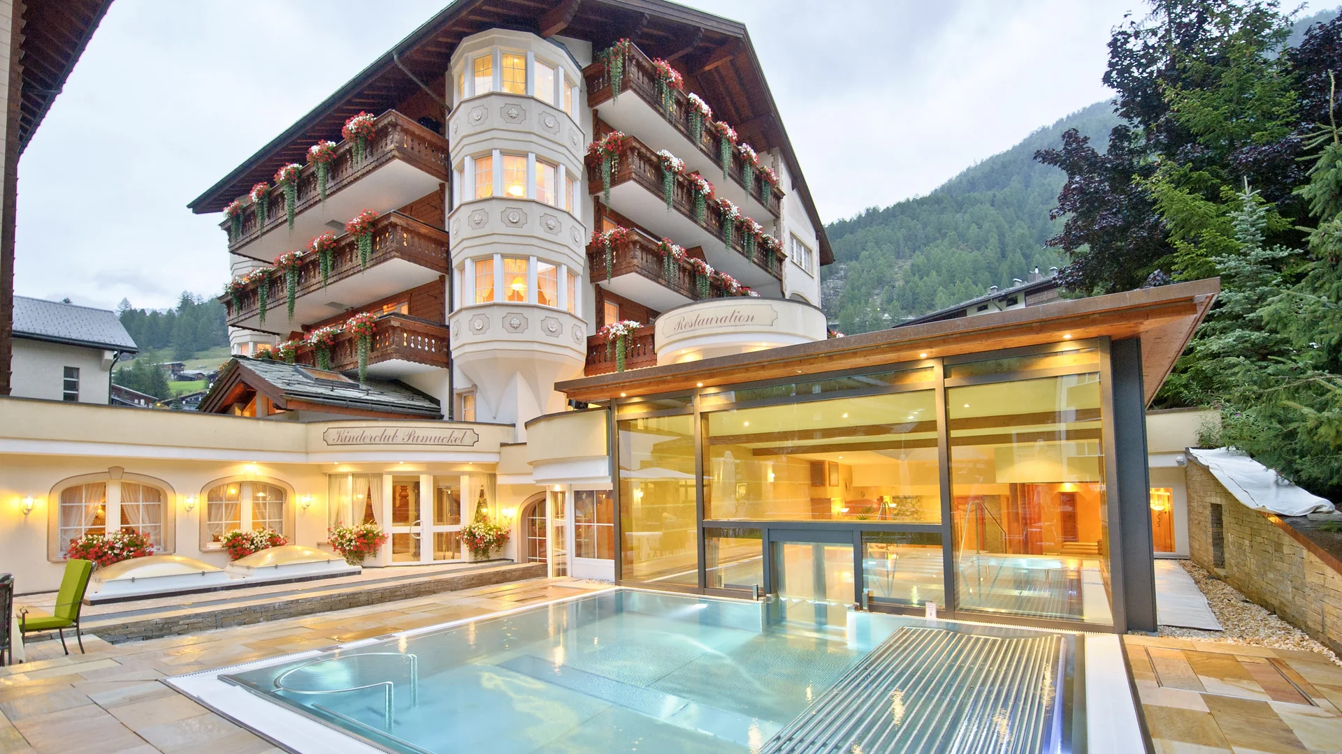 Heated outdoor pool with hotel in the background in summer in the evening.