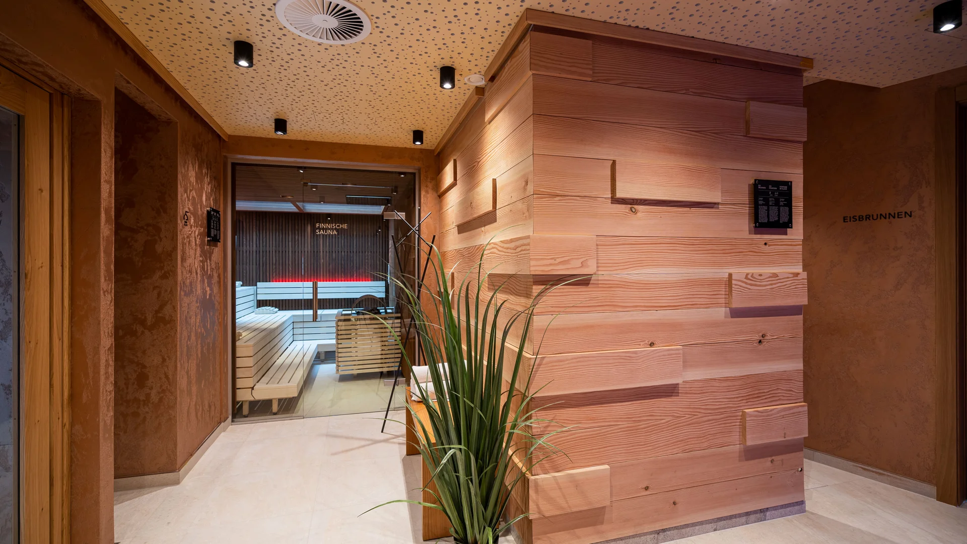 Stimmungsvoll beleuchteter Saunabereich mit Eisbrunnen und Finischer Sauna.