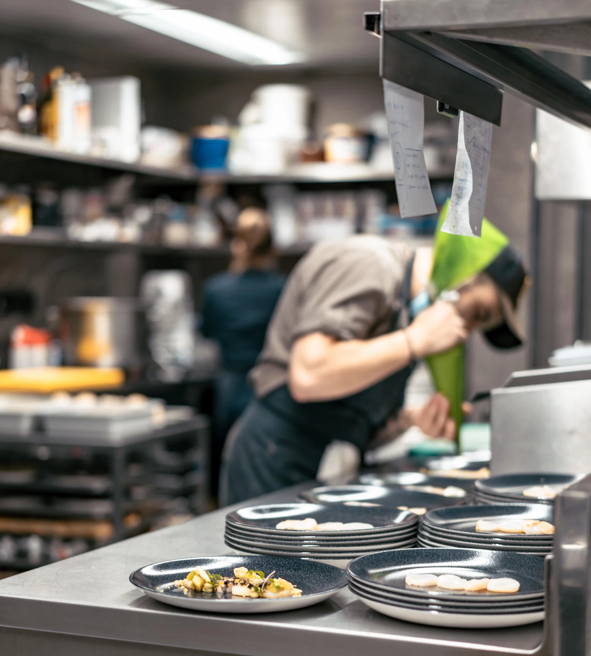 Person am Anrichten von Tellern in der Küche