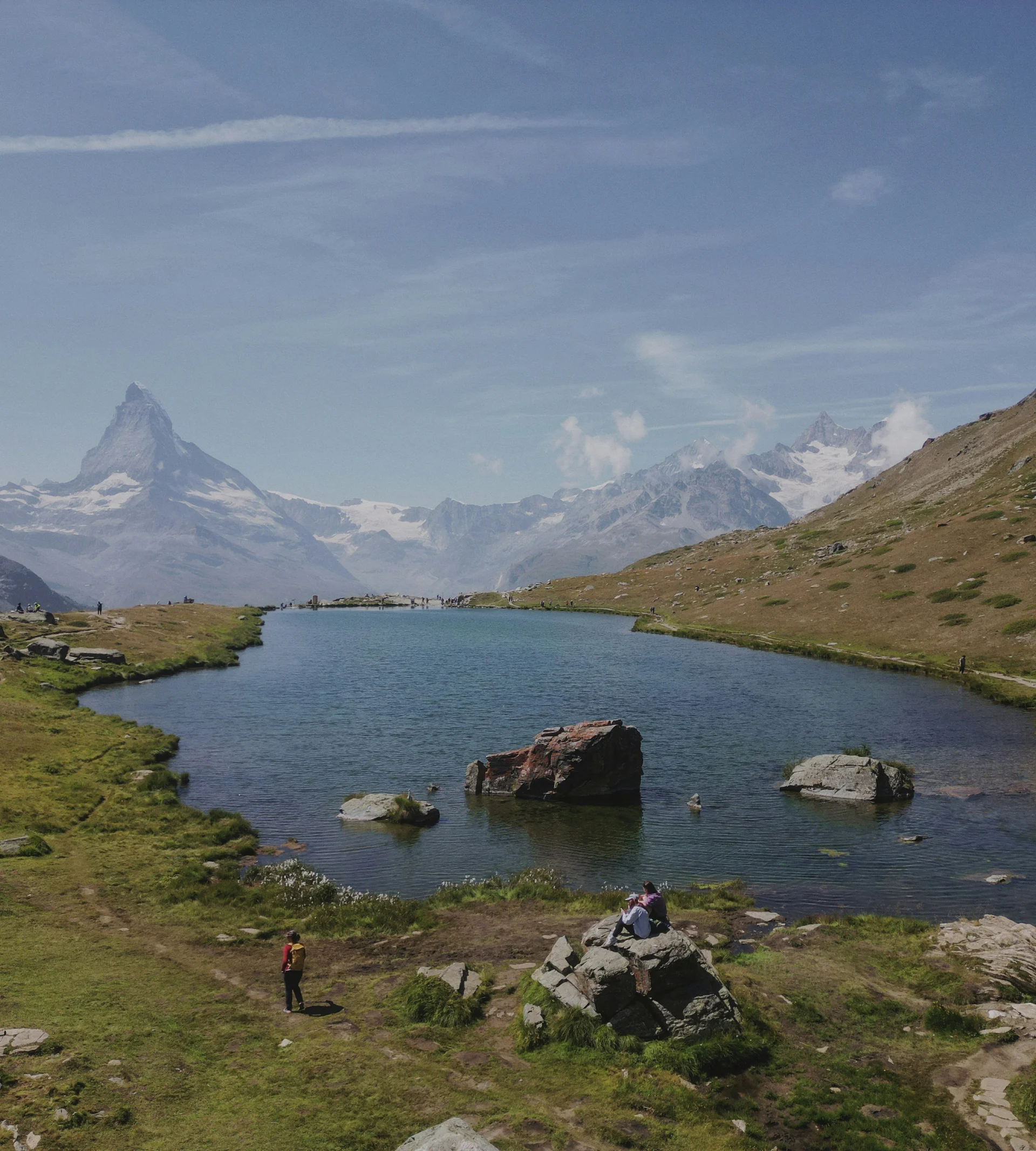 Wandern in Zermatt - Resort La Ginabelle Zermatt Bergsee mit Wanderern und Matterhorn unter klarem Himmel