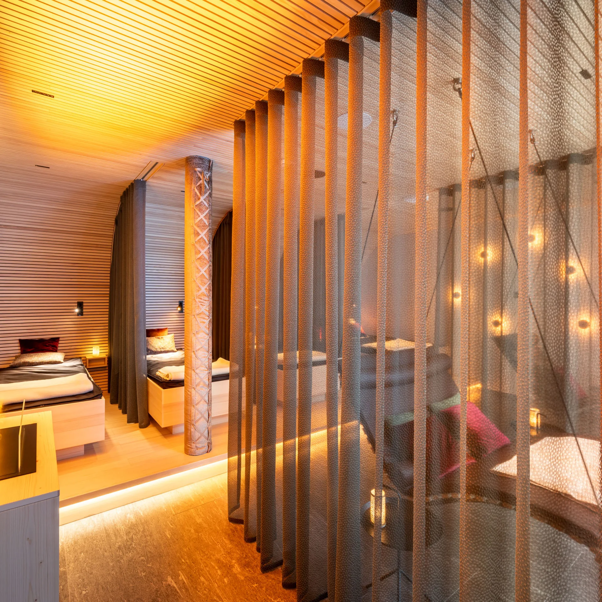 Modernes Zimmer mit zwei Betten, gemütlicher Beleuchtung und Vorhängen