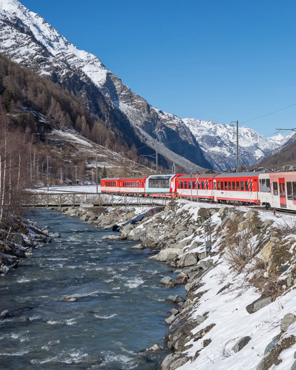 Zug fährt entlag eines Flusses im Winter
