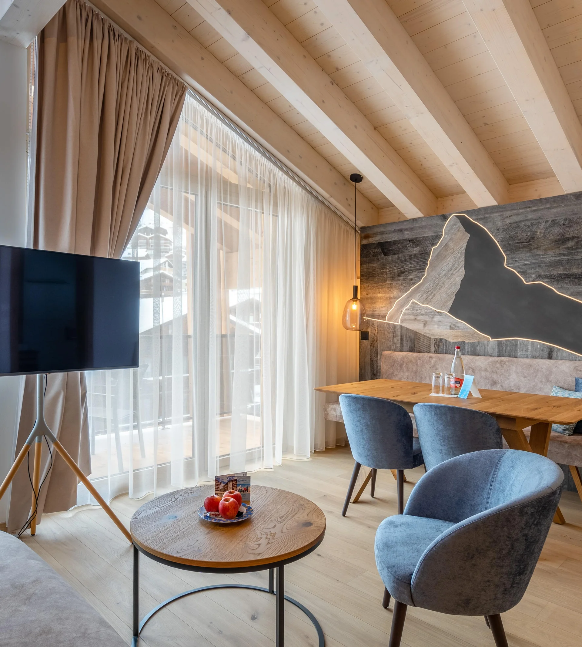 Espace de vie de l'appartement avec télévision et Cervin en bois éclairé