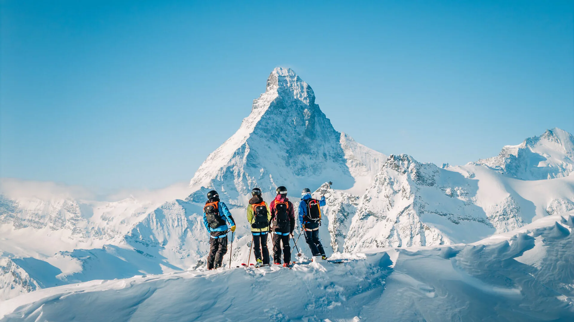 Wintersport Skifahrer vor schneebedecktem Matterhorn unter klarem blauen Himmel