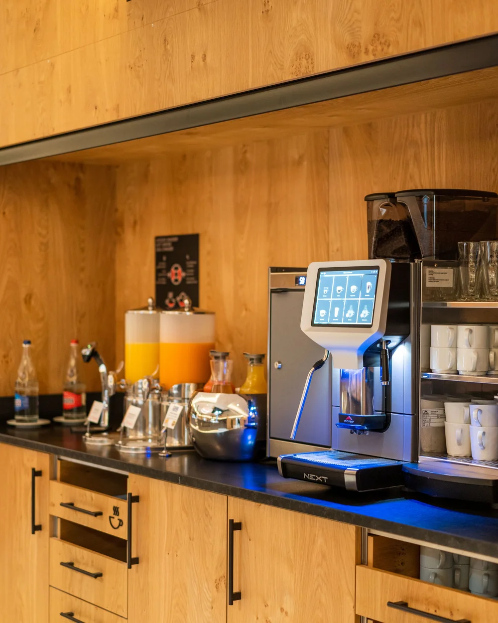 Coffee machine and juice dispenser at the breakfast buffet.