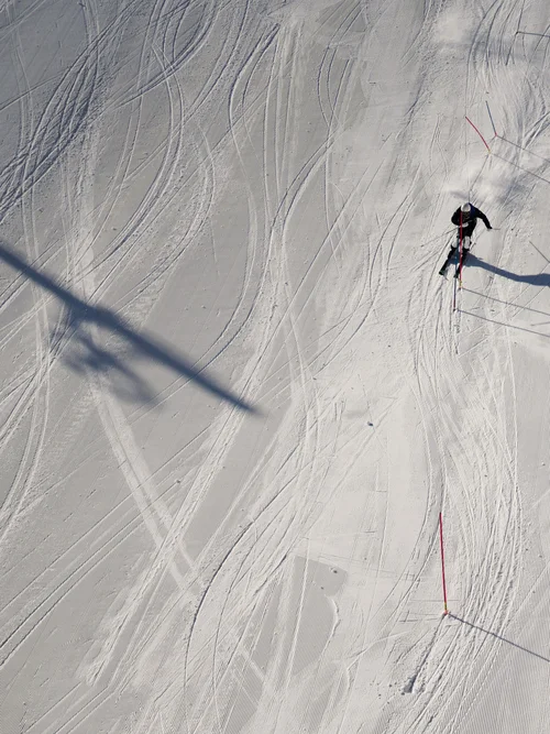 Aktivurlaub in den Bergen - Resort La Ginabelle Zermatt Skifahrer fährt durch Slalomstrecke im Schnee, Schatten und Spuren sichtbar