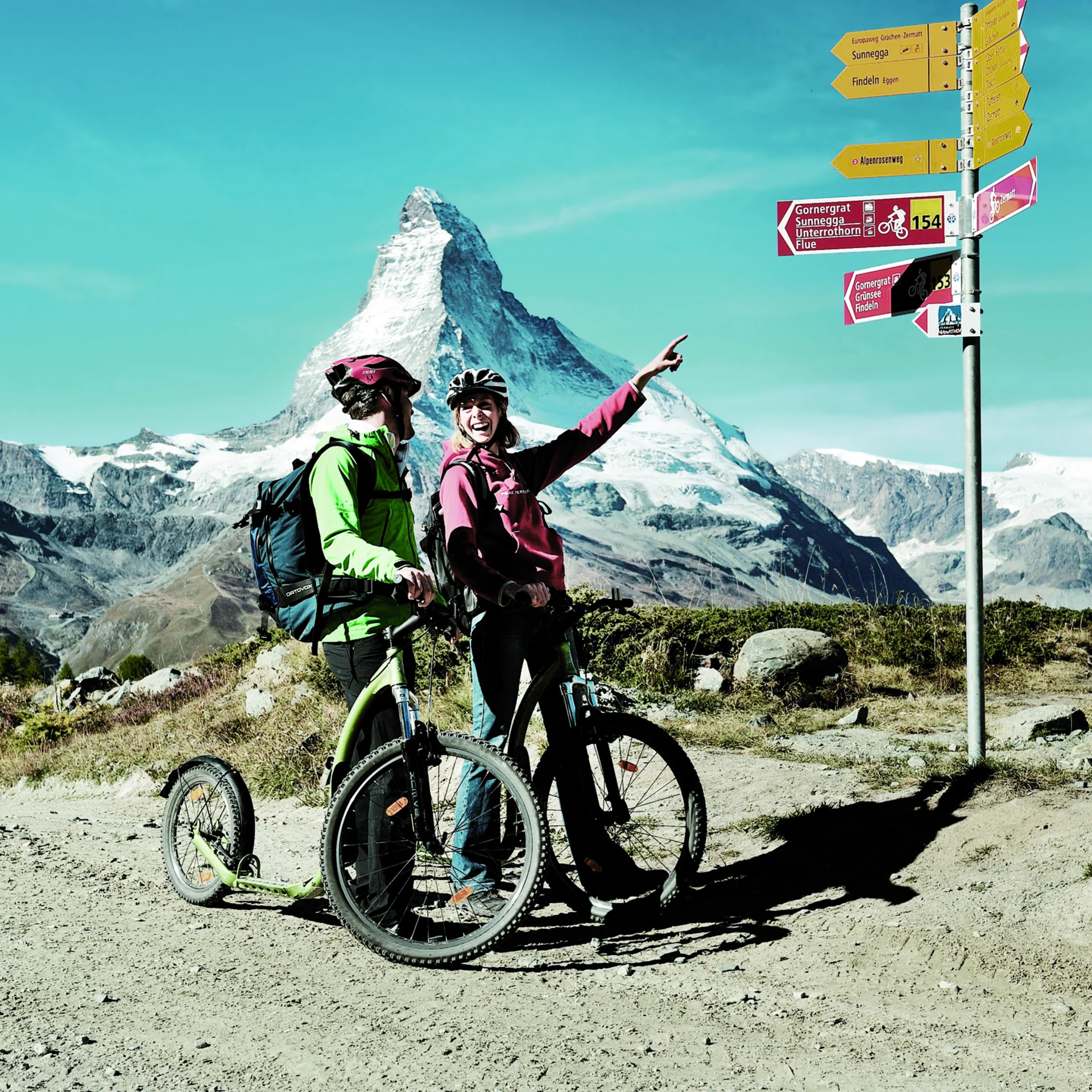 Zwei Personen auf dem Fahrrad vor dem Matterhorn.