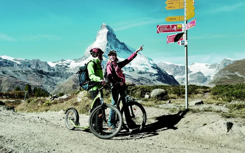 Zwei Personen auf dem Fahrrad vor dem Matterhorn.