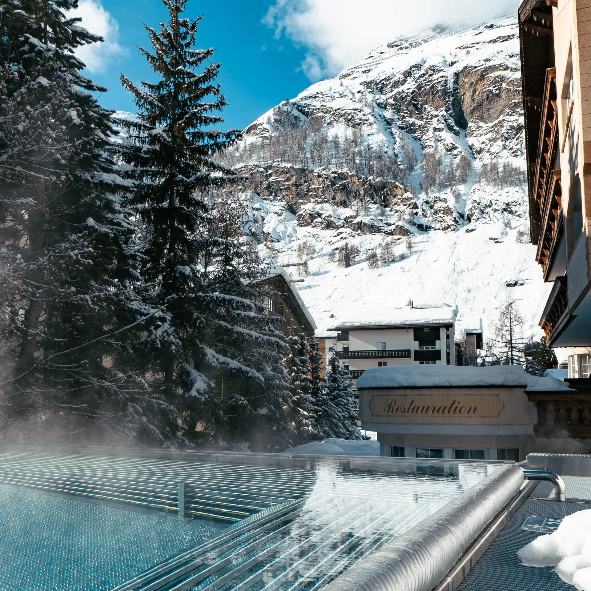 Infinitypool mit Massagedüsen und Aussicht auf die verschneiten Berge im Winter.