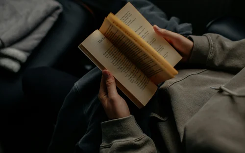 Rooms, Apartments & Suites - Resort La Ginabelle Zermatt Person reading a book and turning a page