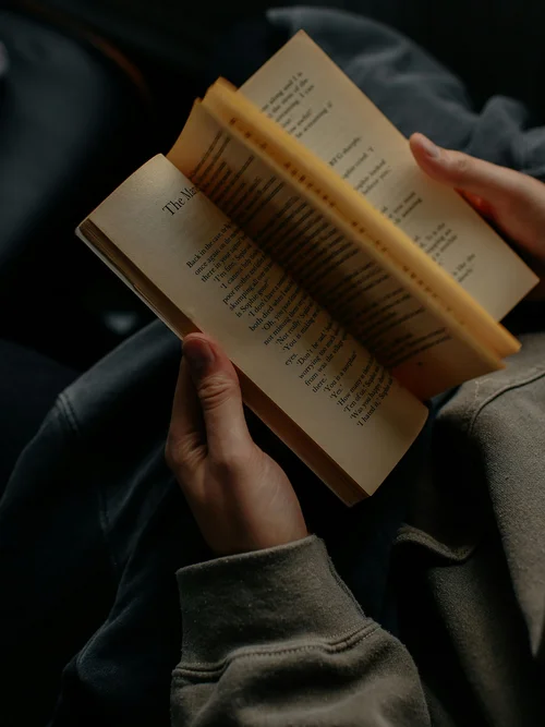 Person liest ein Buch und blättert eine Seite um