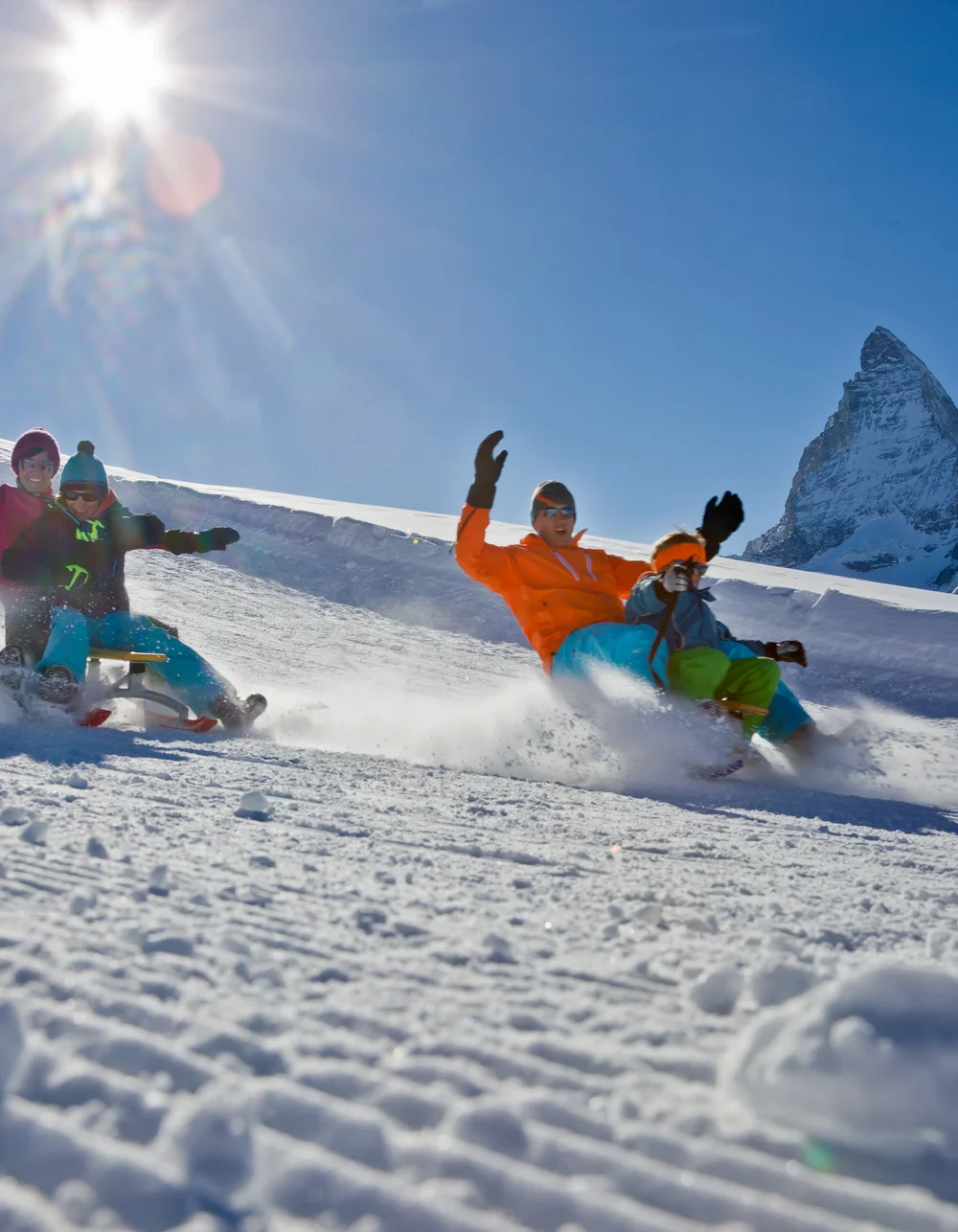 Familie am Schlittenfahren bei sonnigem Wetter.