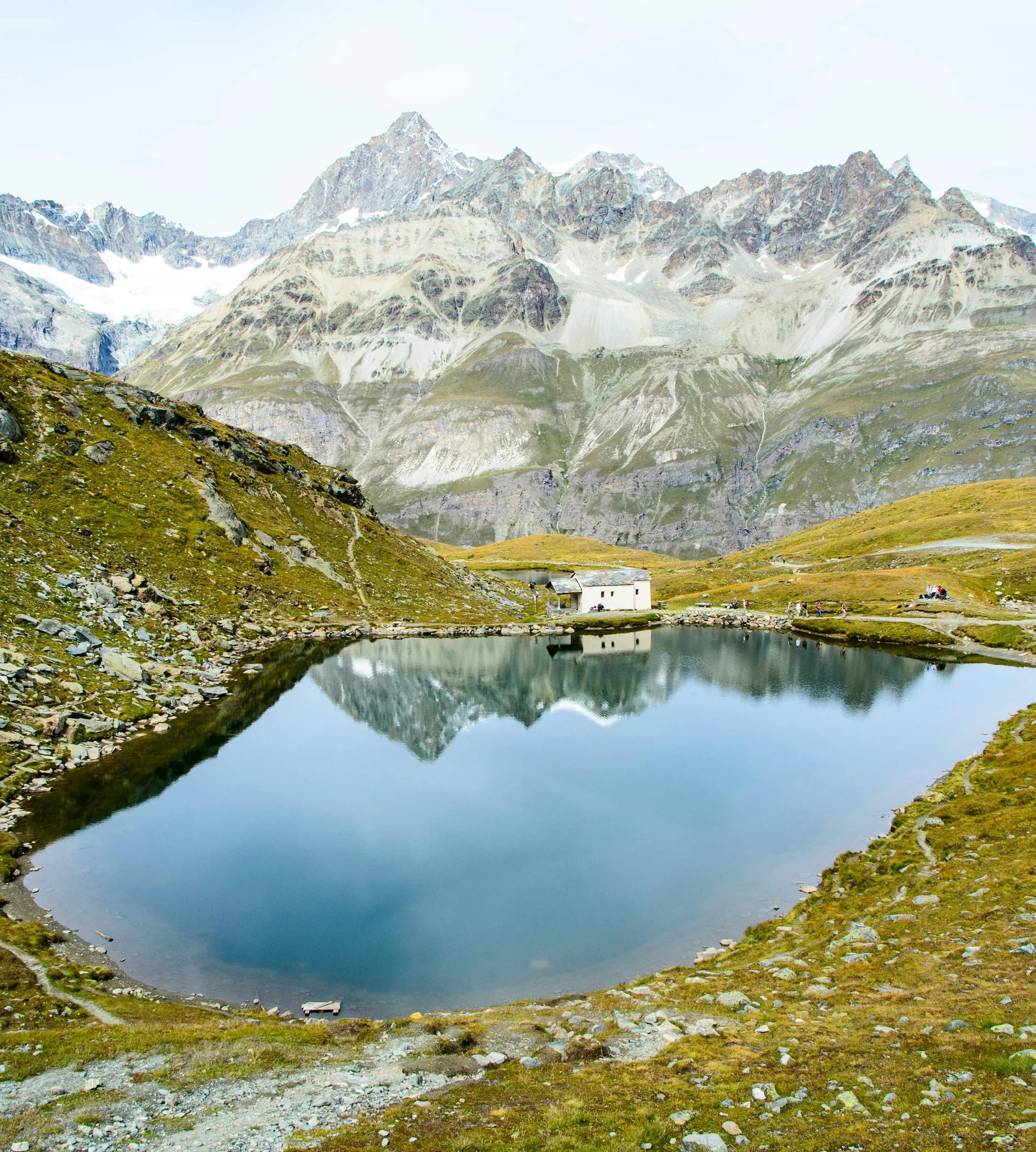 Wandern in Zermatt - Resort La Ginabelle Zermatt Bergsee mit Spiegelung der Alpen und kleinem Haus an Ufer