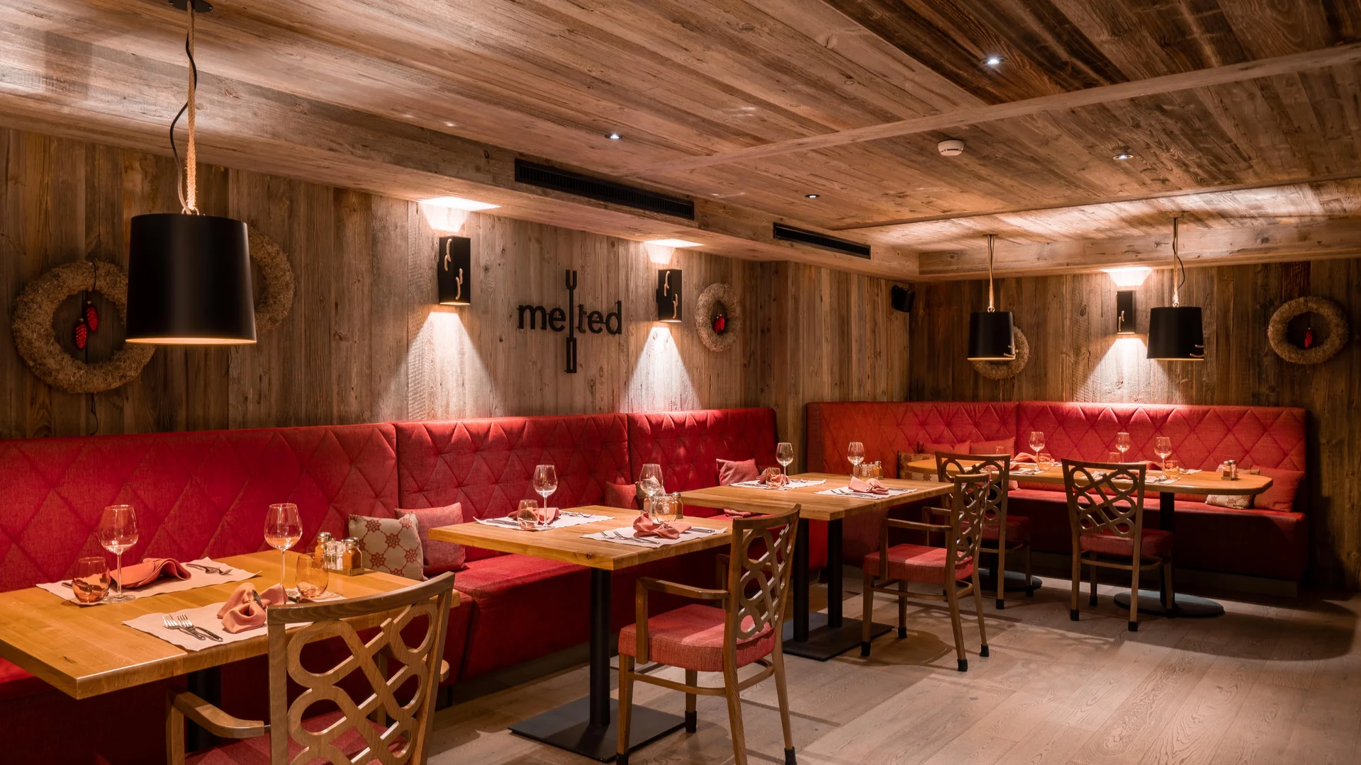 Restaurants at La Ginabelle - Resort La Ginabelle Zermatt Cozy restaurant atmosphere with wood paneling and red upholstery.