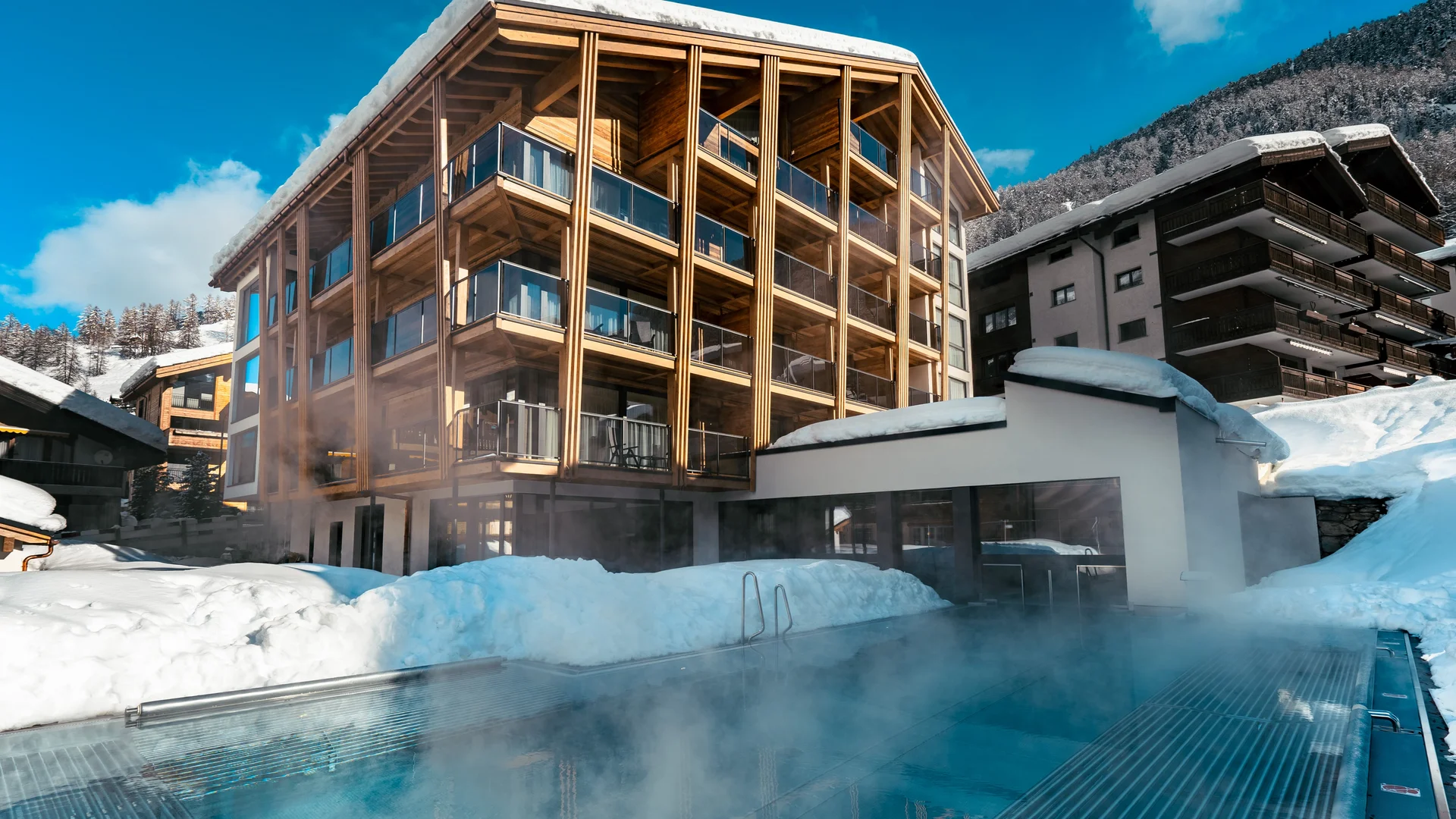 Schneebedecktes Hotel mit Infinitypool