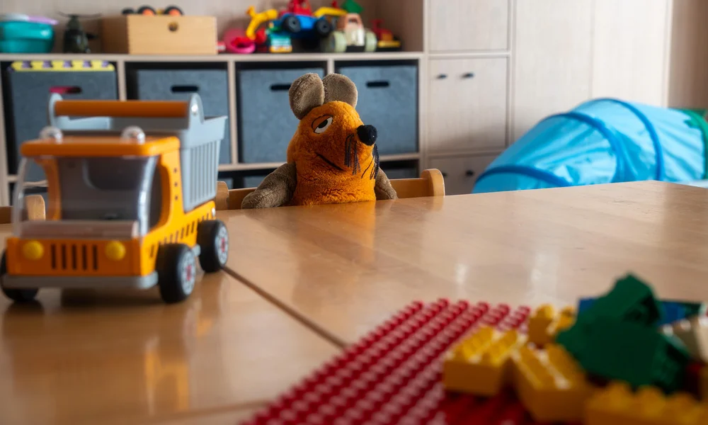 Spielzeug und Stofftier in einem gemütlichen Kinderzimmer.