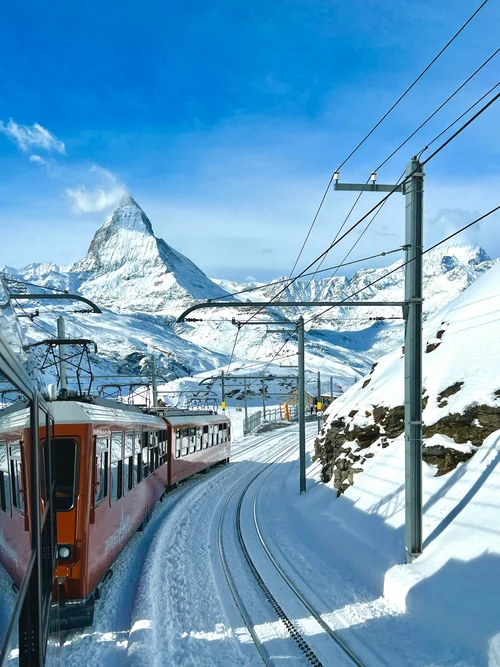 Zug fährt Schneegleis mit Matterhorn im Hintergrund