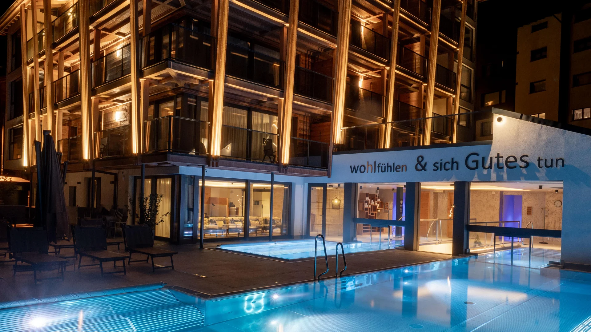 Resort La Ginabelle Zermatt: Ihr 4*S Wellnessresort in Zermatt Beleuchtetes Hotel mit Infinitypool in der Nacht.