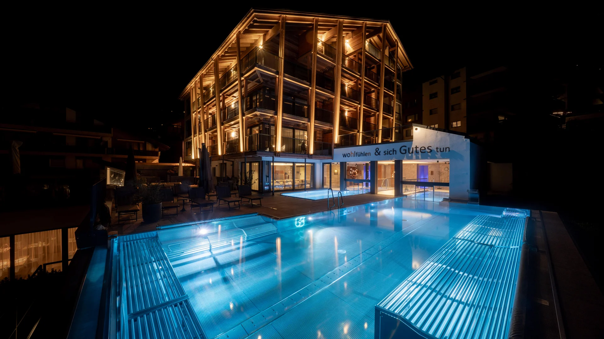 Our energy - Resort La Ginabelle Zermatt Illuminated hotel with infinity pool at night.