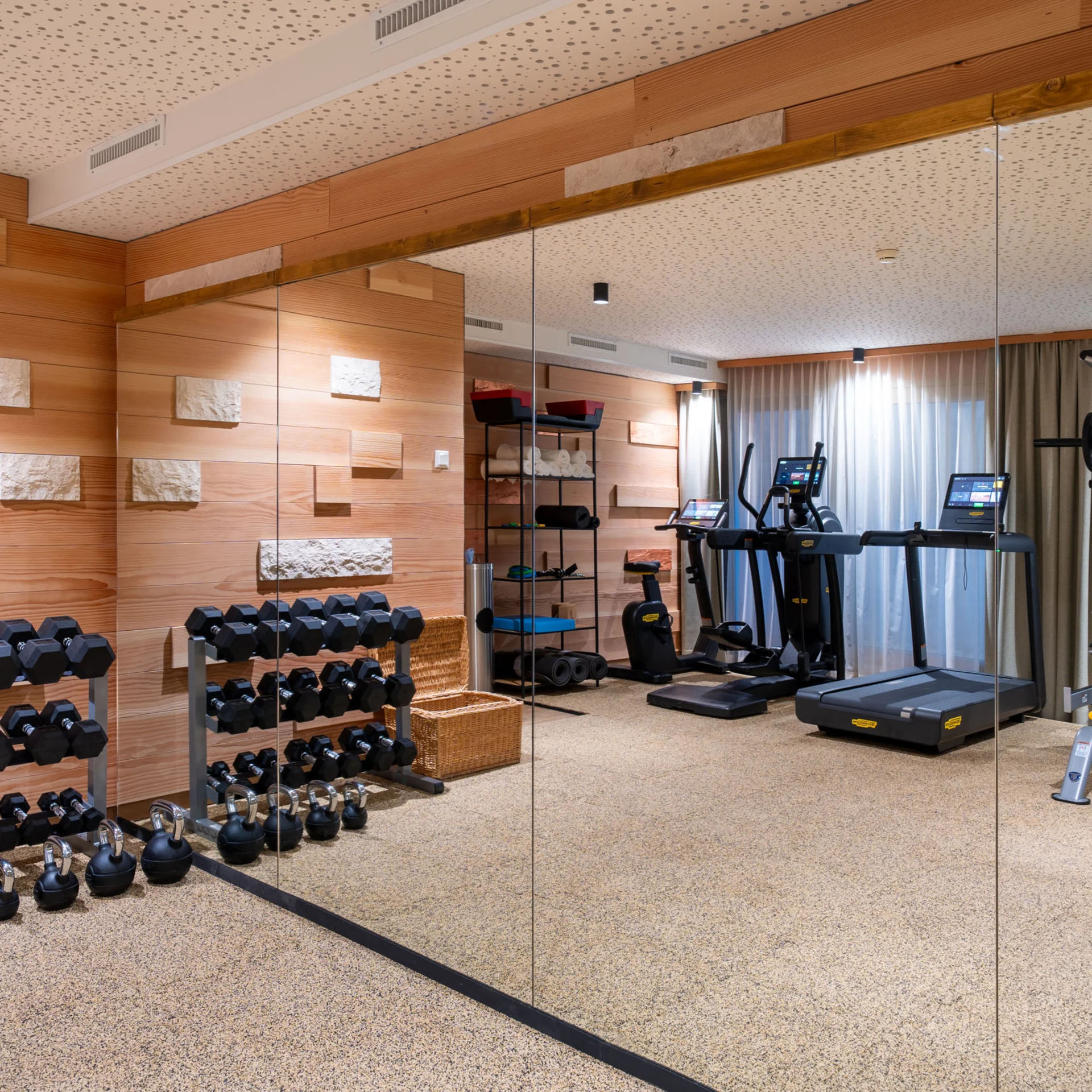 Moderner Fitnessraum mit Hanteln, Laufband und Kraftmaschinen