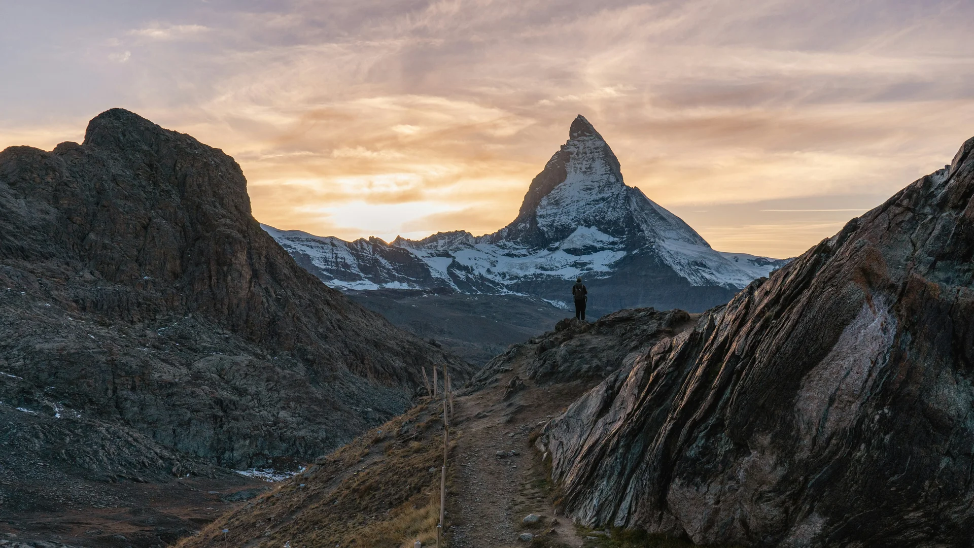 Aktivurlaub in den Bergen - Resort La Ginabelle Zermatt Wanderer vor Matterhorn bei Sonnenuntergang in den Alpen