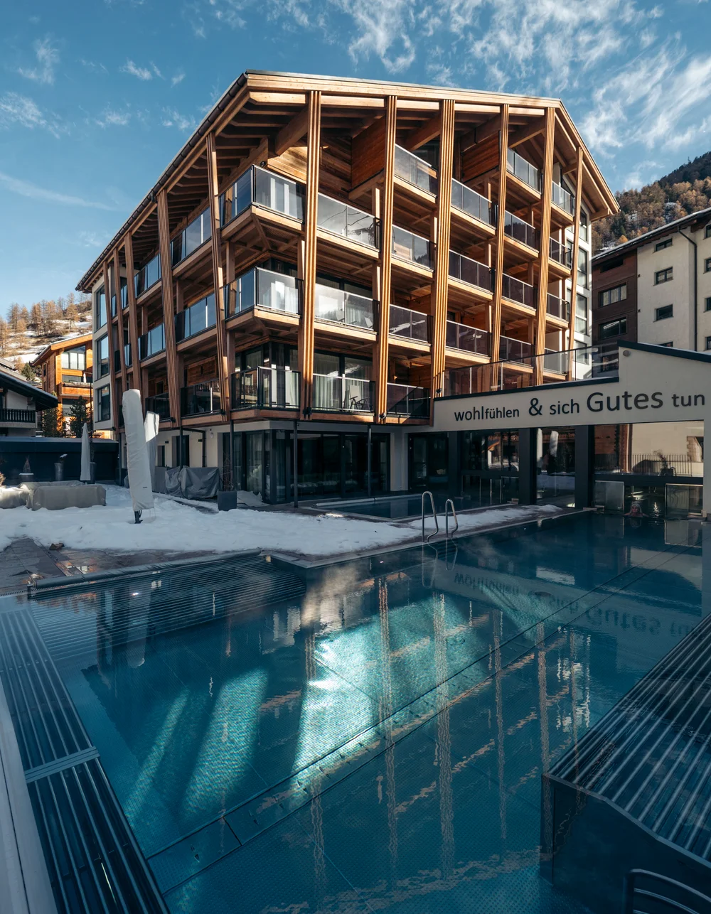 acotar Modernes Hotel mit Holzfassade und beheiztem Außenpool im Winter