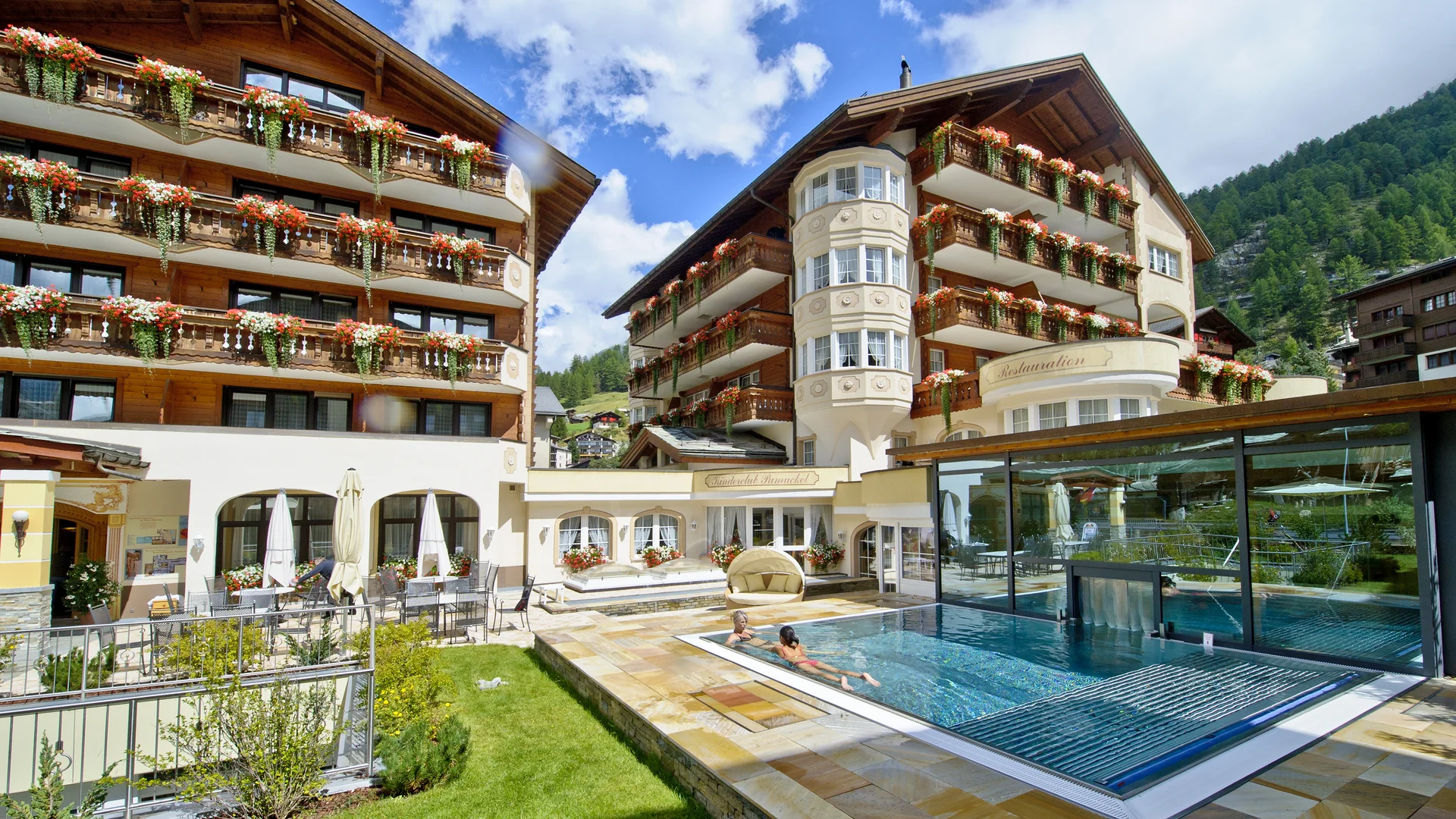 Your 4*S hotel in Zermatt - Resort La Ginabelle Zermatt Hotel with outdoor pool and garden in summer during nice weather.