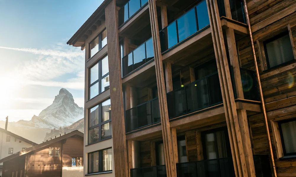 Our energy - Resort La Ginabelle Zermatt Hotel facade with the Matterhorn and sunset in the background.