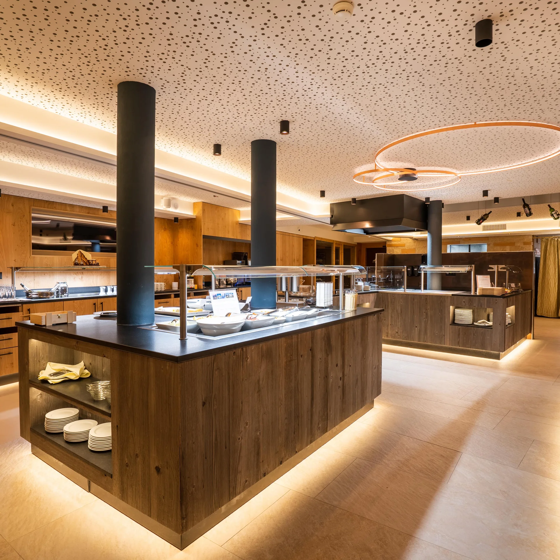 Frühstücksbuffet mit Holzverkleidung und indirekter Beleuchtung.