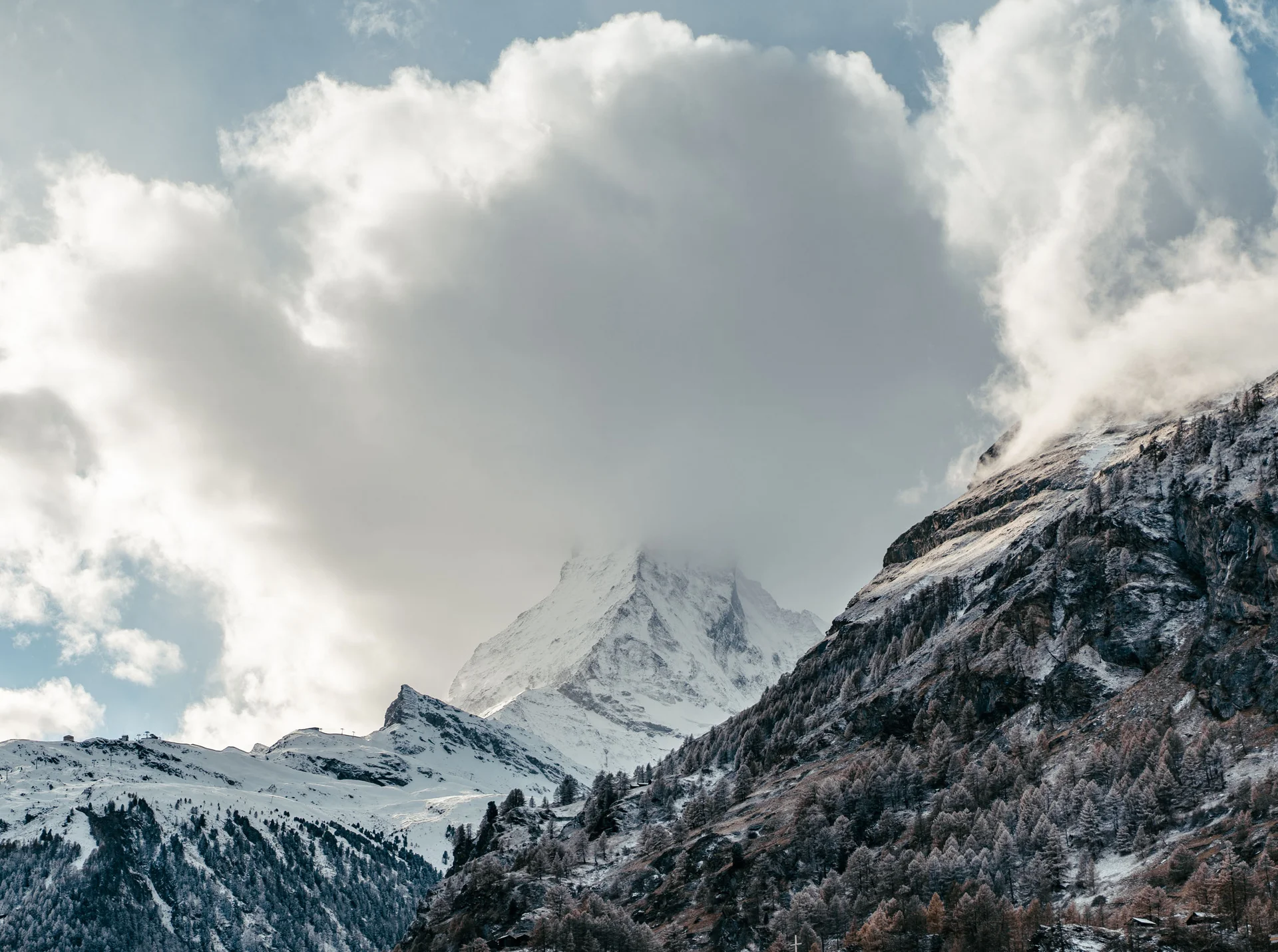 Schneebedeckter Berggipfel teilweise von Wolken bedeckt