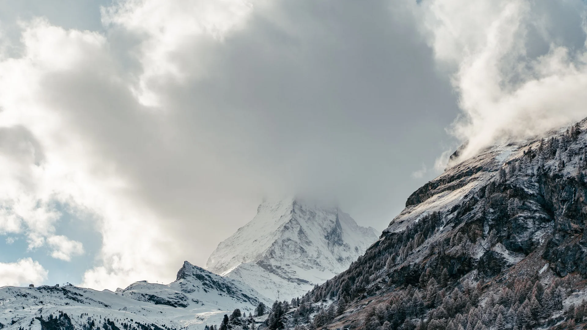 Aktivurlaub in den Bergen - Resort La Ginabelle Zermatt Schneebedeckter Berggipfel teilweise von Wolken bedeckt