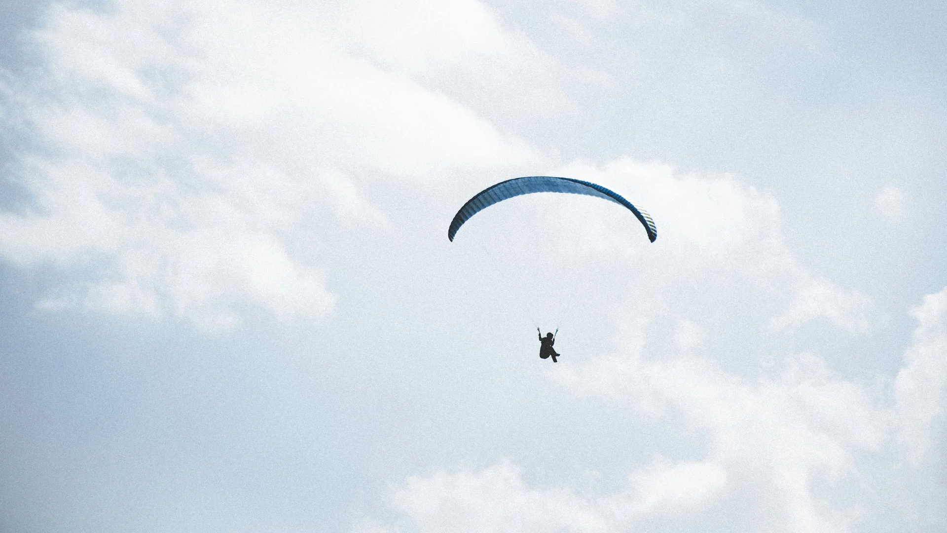 Ausflugsziele in Zermatt - Resort La Ginabelle Zermatt Person beim Gleitschirmfliegen hoch am Himmel mit Wolken