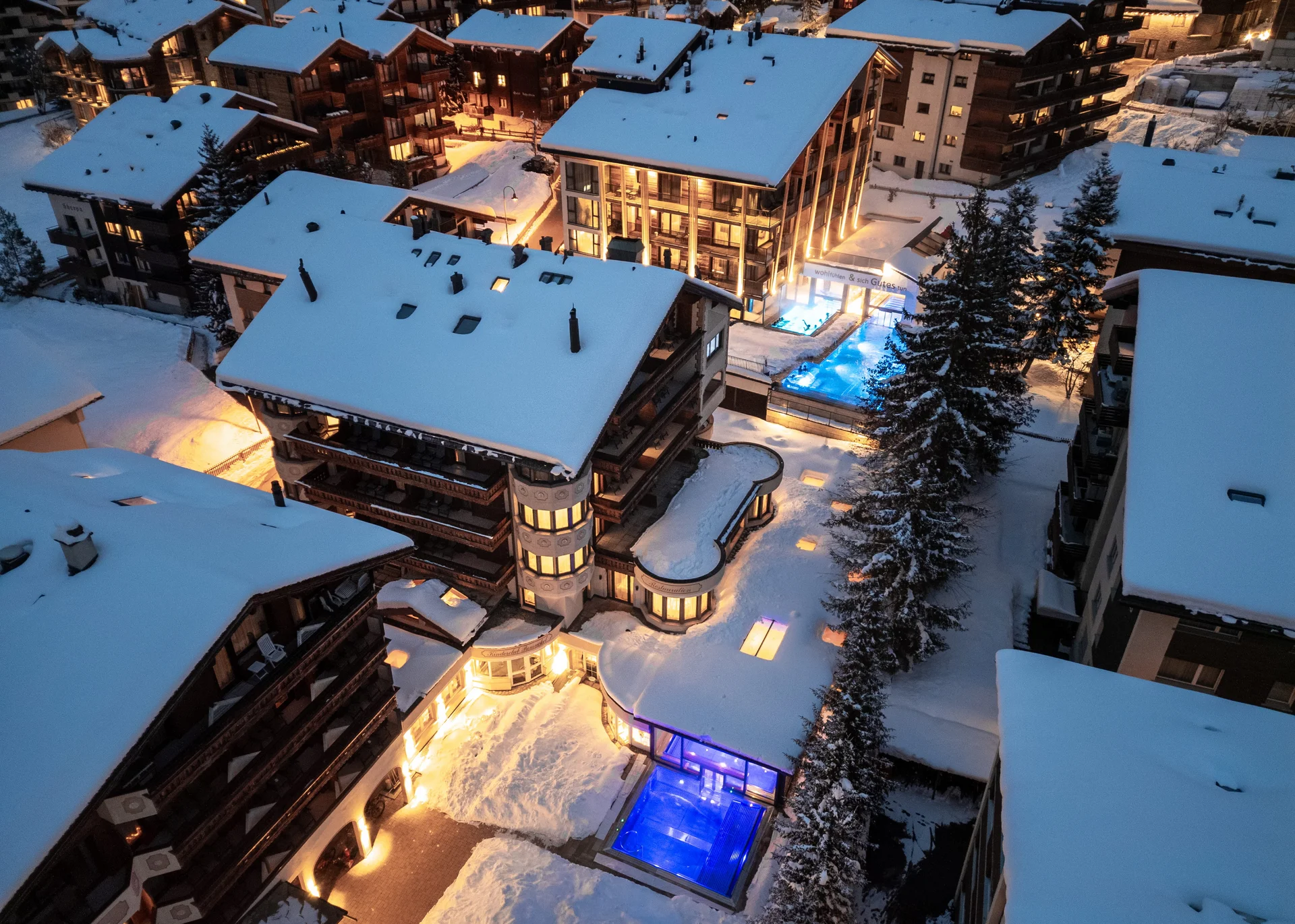 Resort La Ginabelle Zermatt: Ihr 4*S Wellnessresort in Zermatt Schneebedecktes Gebäude mit drei beheizten Aussenpools.