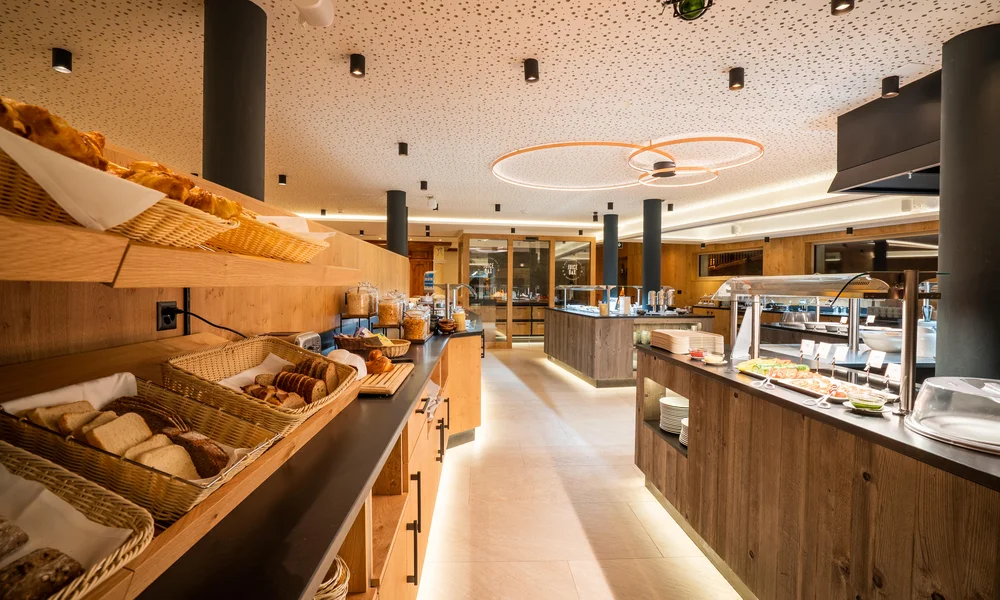 Restaurants au La Ginabelle - Resort La Ginabelle Zermatt Buffet petit-déjeuner avec un habillage en bois et un éclairage indirect.