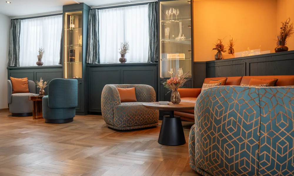 Fumoir avec des fauteuils, une cheminée électrique et un canapé