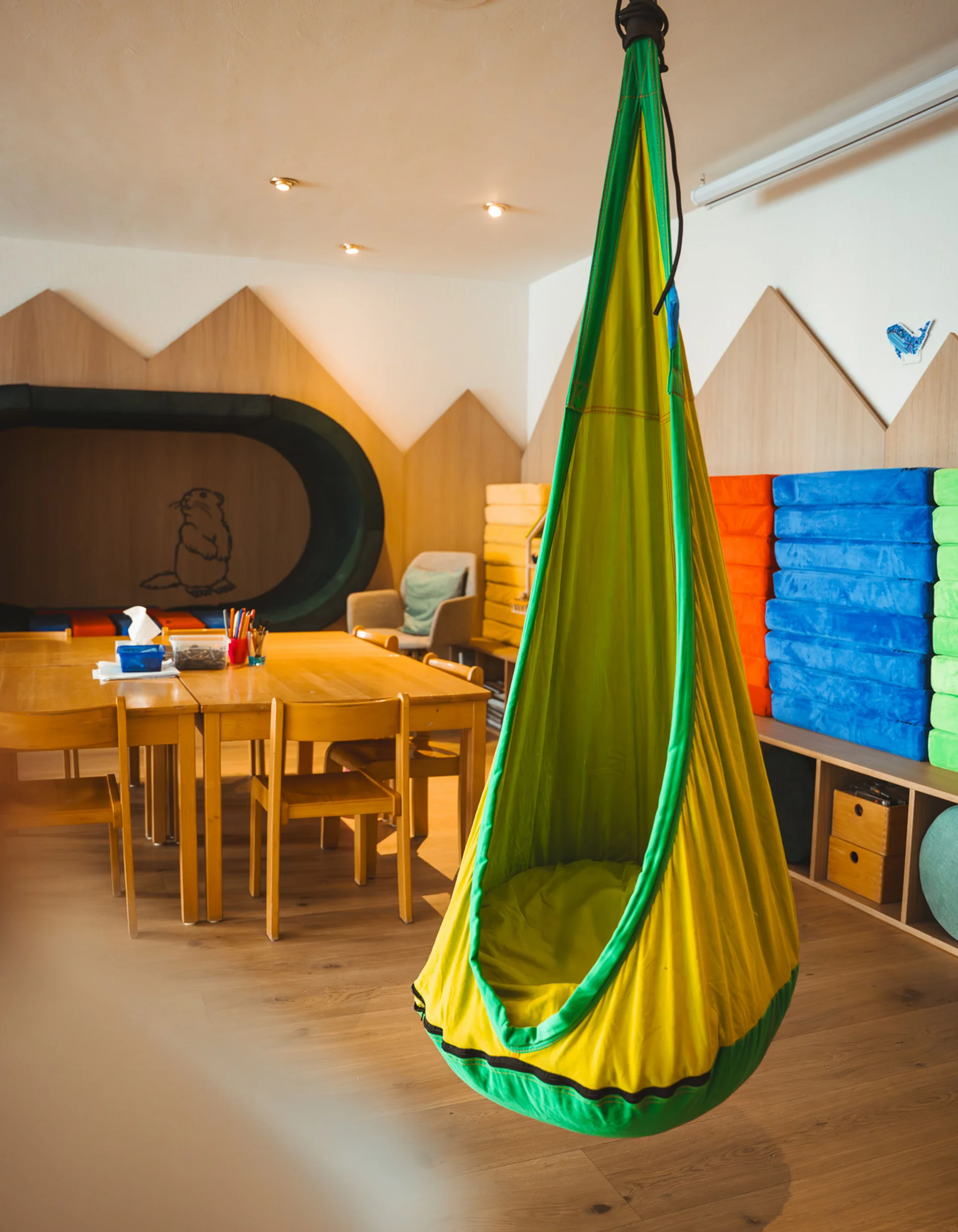 Bunter Hängesitz in einem modernen, gemütlichen Kinderzimmer