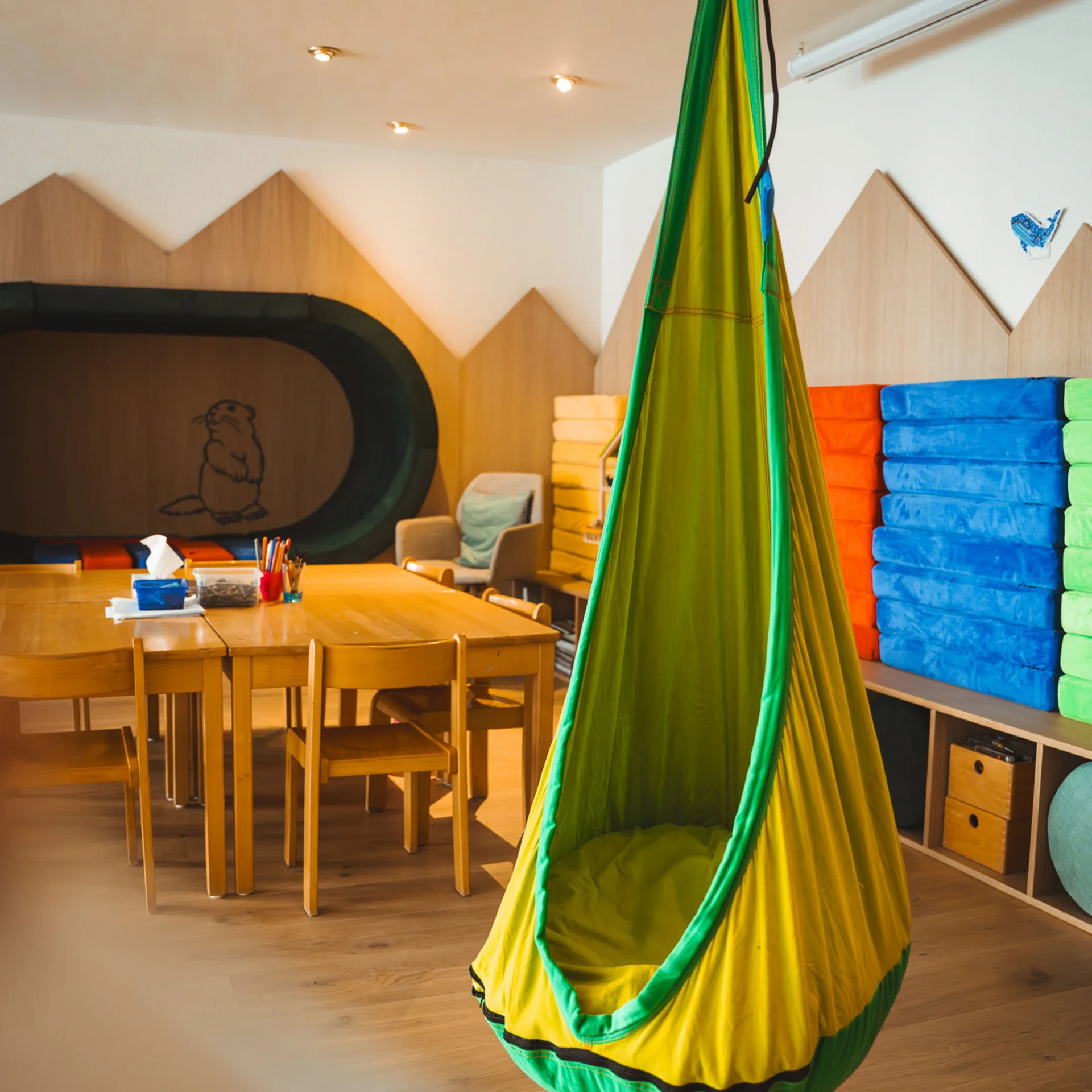 Bunter Hängesitz in einem modernen, gemütlichen Kinderzimmer