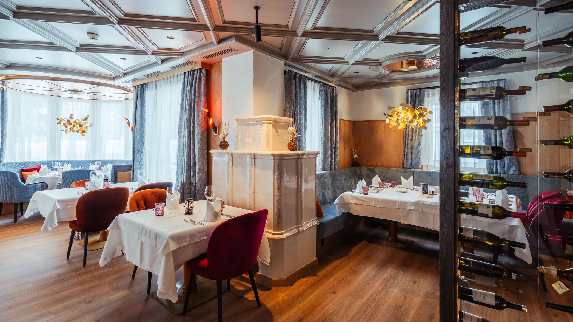 Modernes Restaurant mit traditionellem Kacheloffen und Weinshowstück.