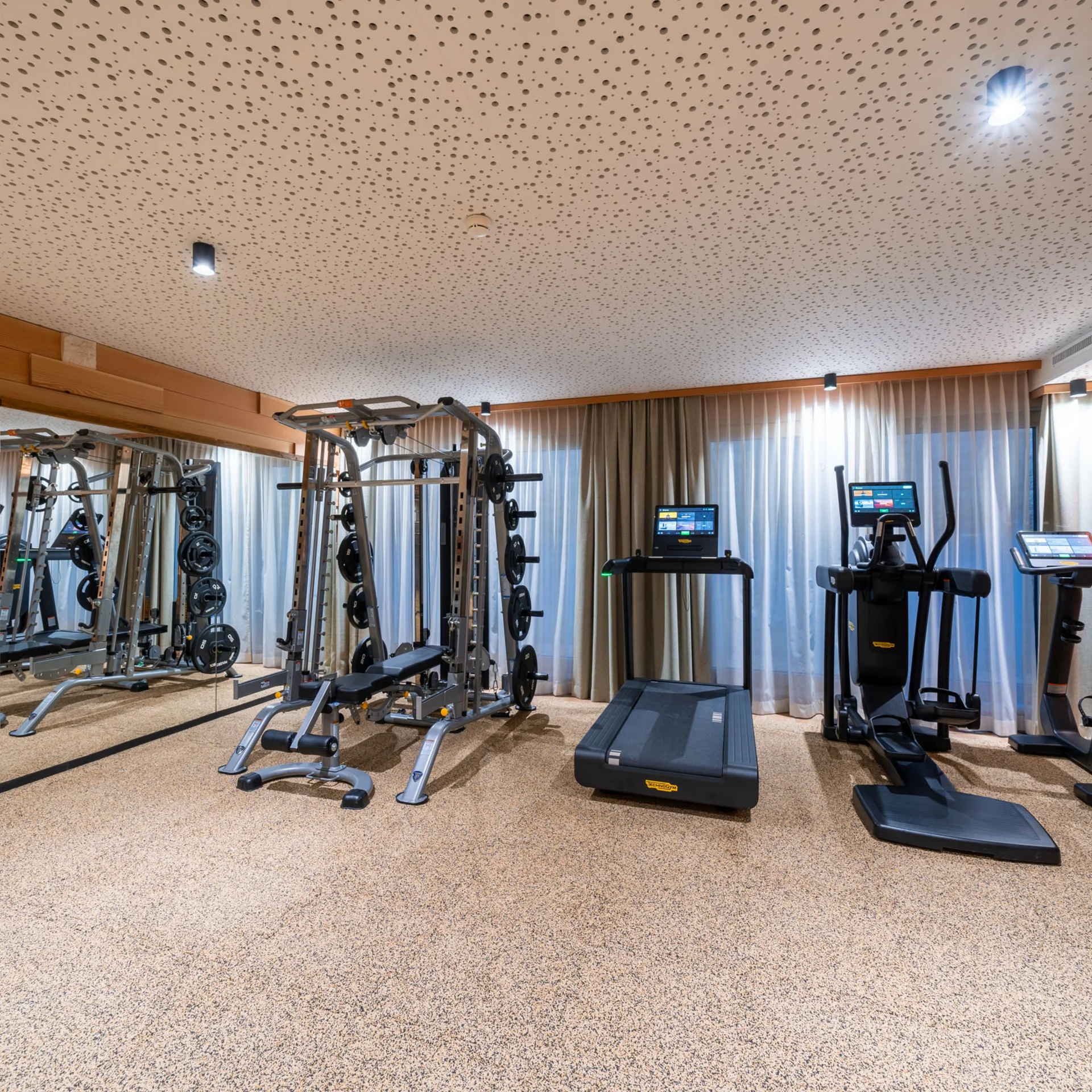 Moderner Fitnessraum mit Laufband, Crosstrainer und Kraftstation