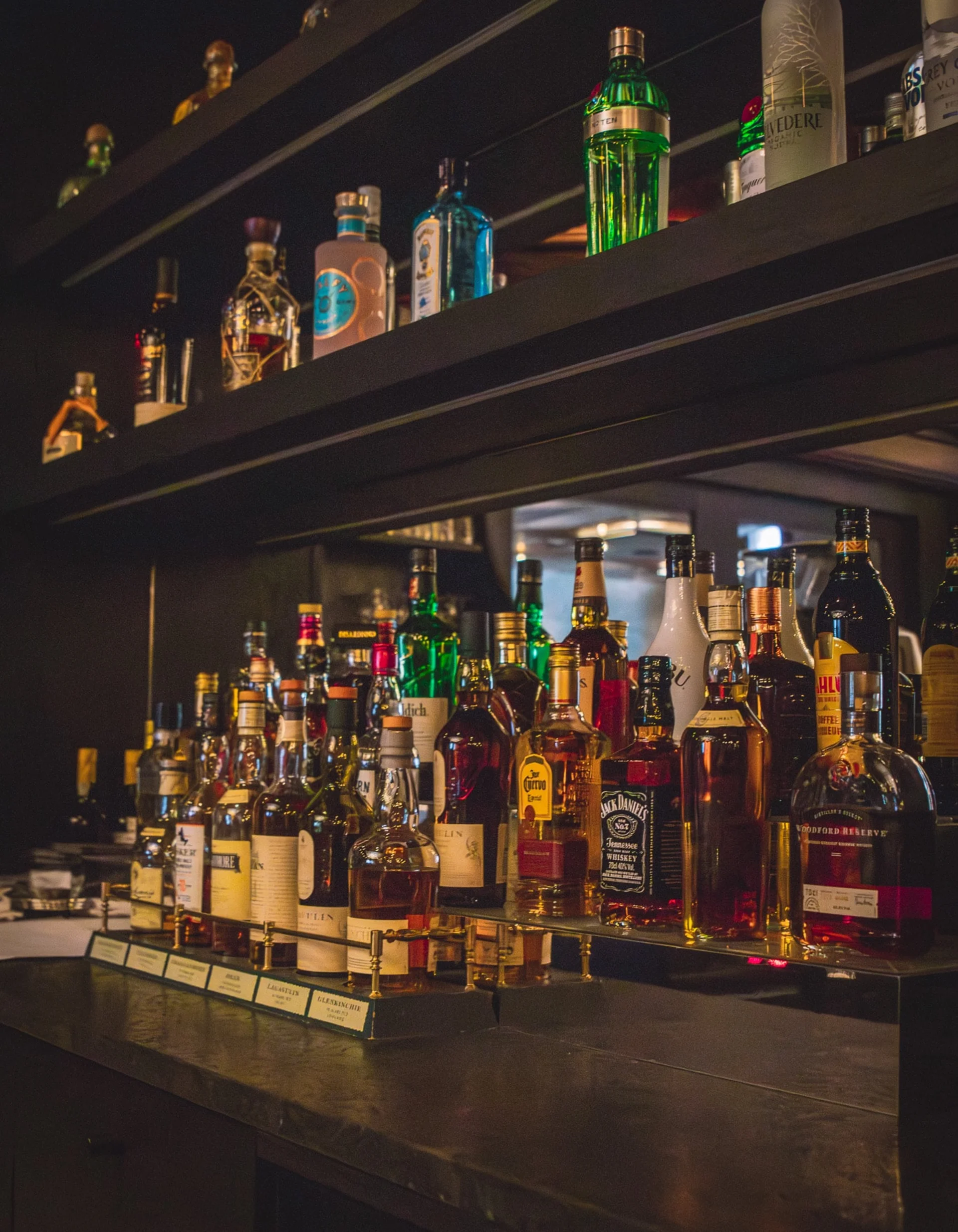 Flaschen in einer beleuchteten Vitrine.