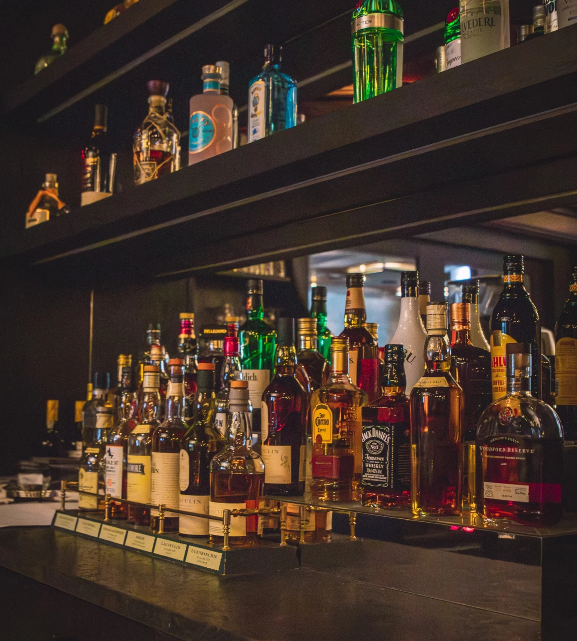 Flaschen in einer beleuchteten Vitrine.