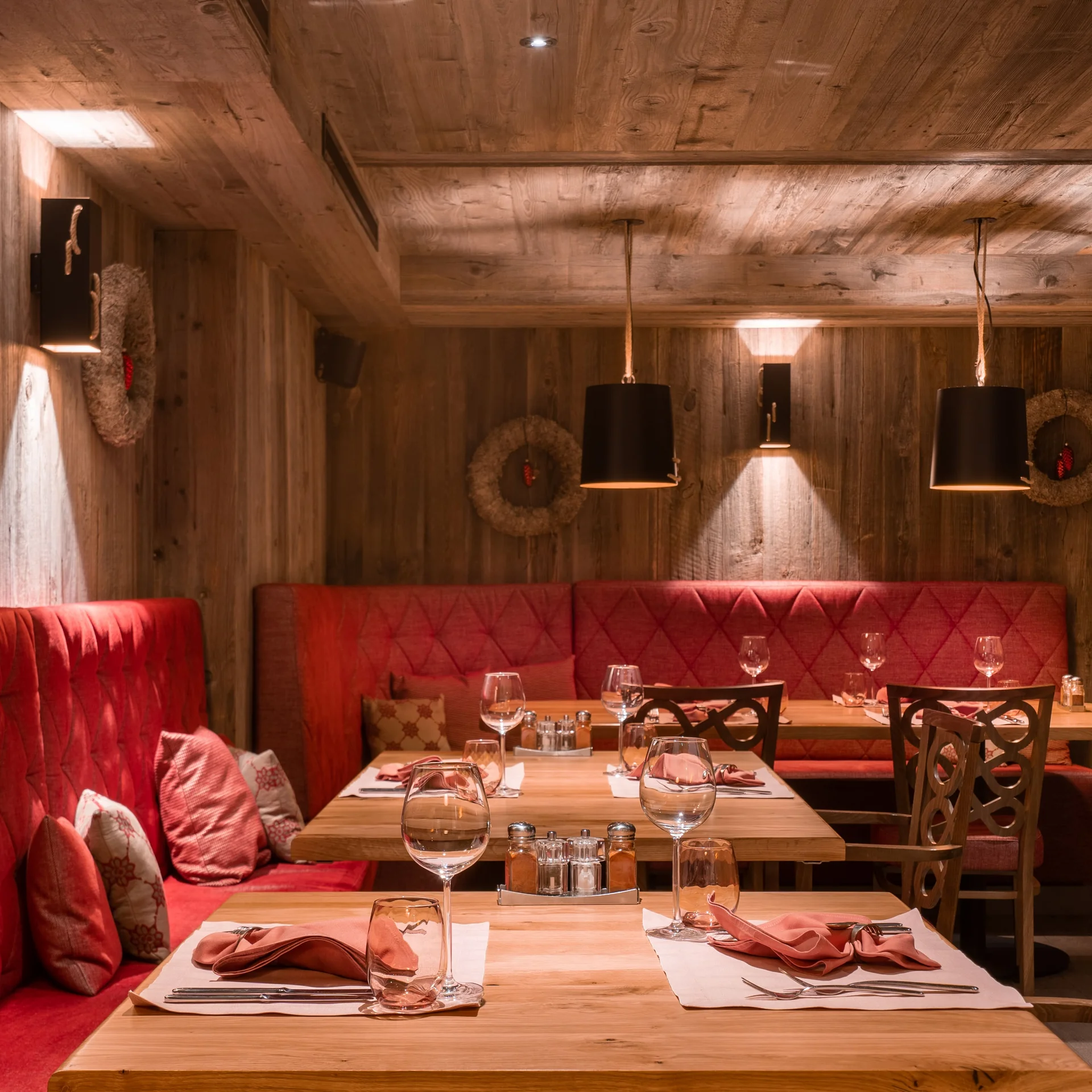 Gemütliches Restaurantambiente mit Holzverkleidung und roten Polstern.