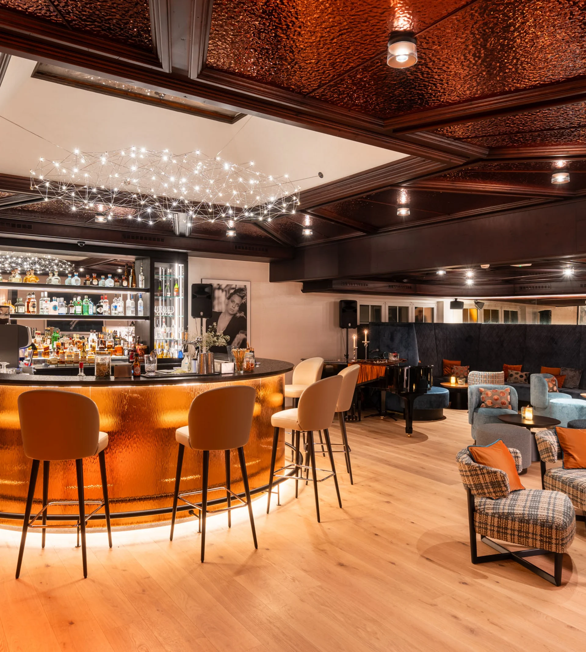 Elegante Bar mit kupferfarbenem Tresen und gemütlichem Lounge-Bereich