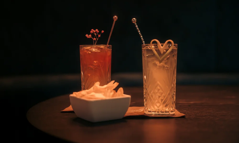 zwei exquisite Cocktails mit Chips  auf einem Tisch in der Bar