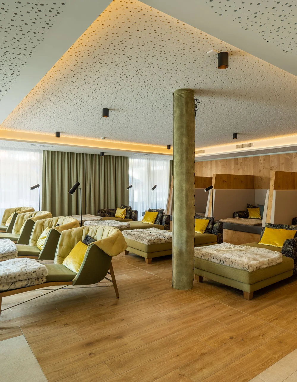 Salle de repos aménagée avec ambiance, équipée de chaises longues et de couchettes.